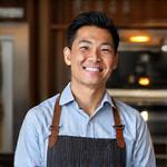 Portrait of Alex Chen, EmberGrind's Head Roaster, confidently smiling in a professional setting.